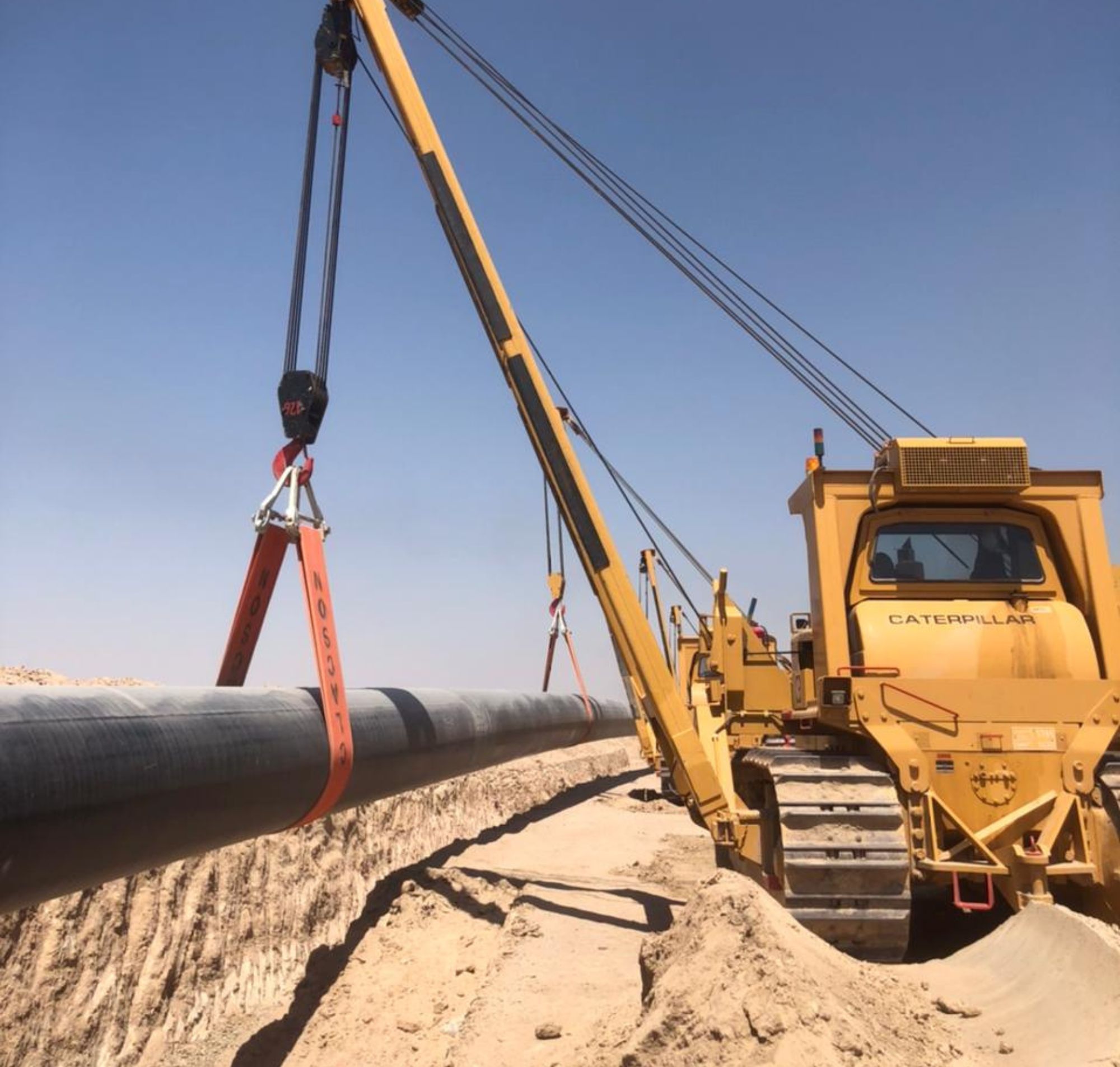 Bonatti pipeline projects in action, a pipe being put in place with heavy machinery.